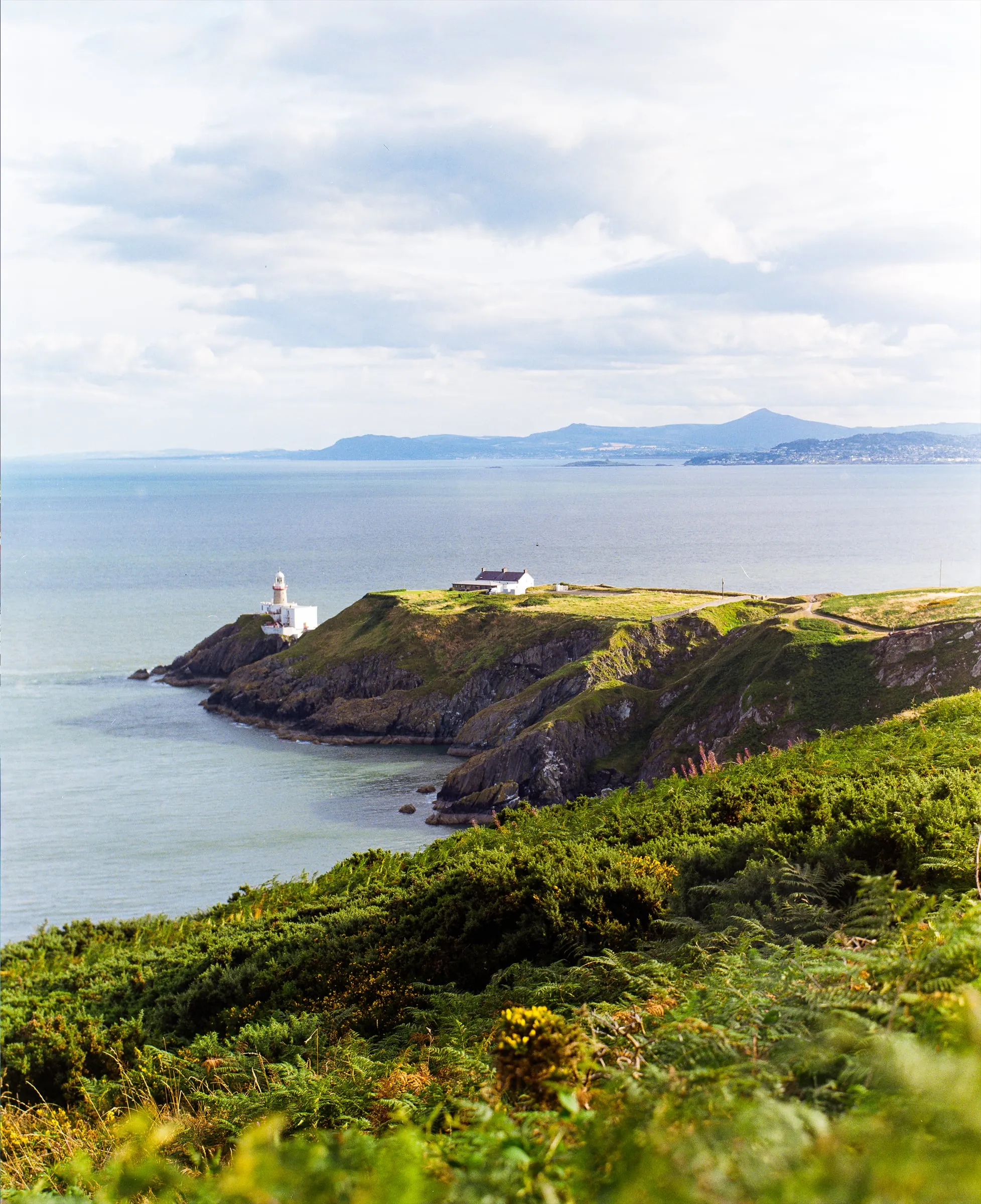 Baily Lighthouse on a green headland over the Irish Sea