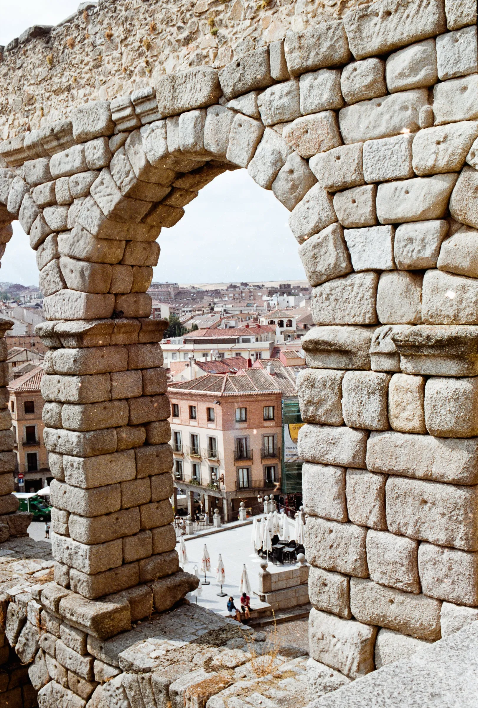 Roman aqueduct arch framing the rooftops of Segovia
