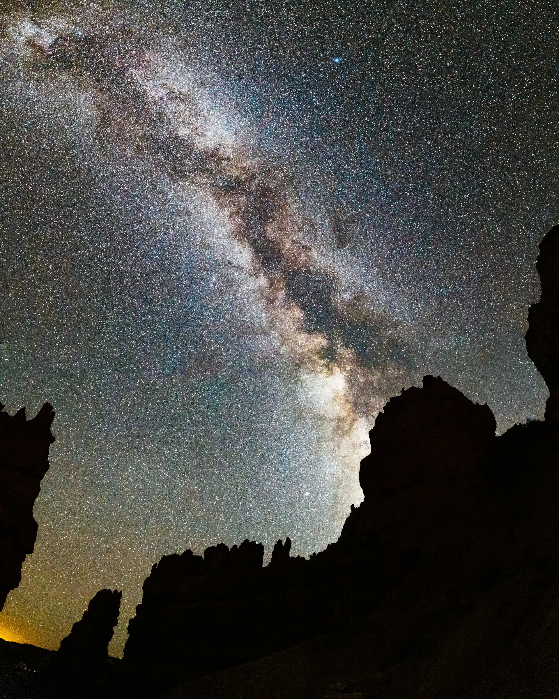 The Milky Way rising over silhouetted rock formations