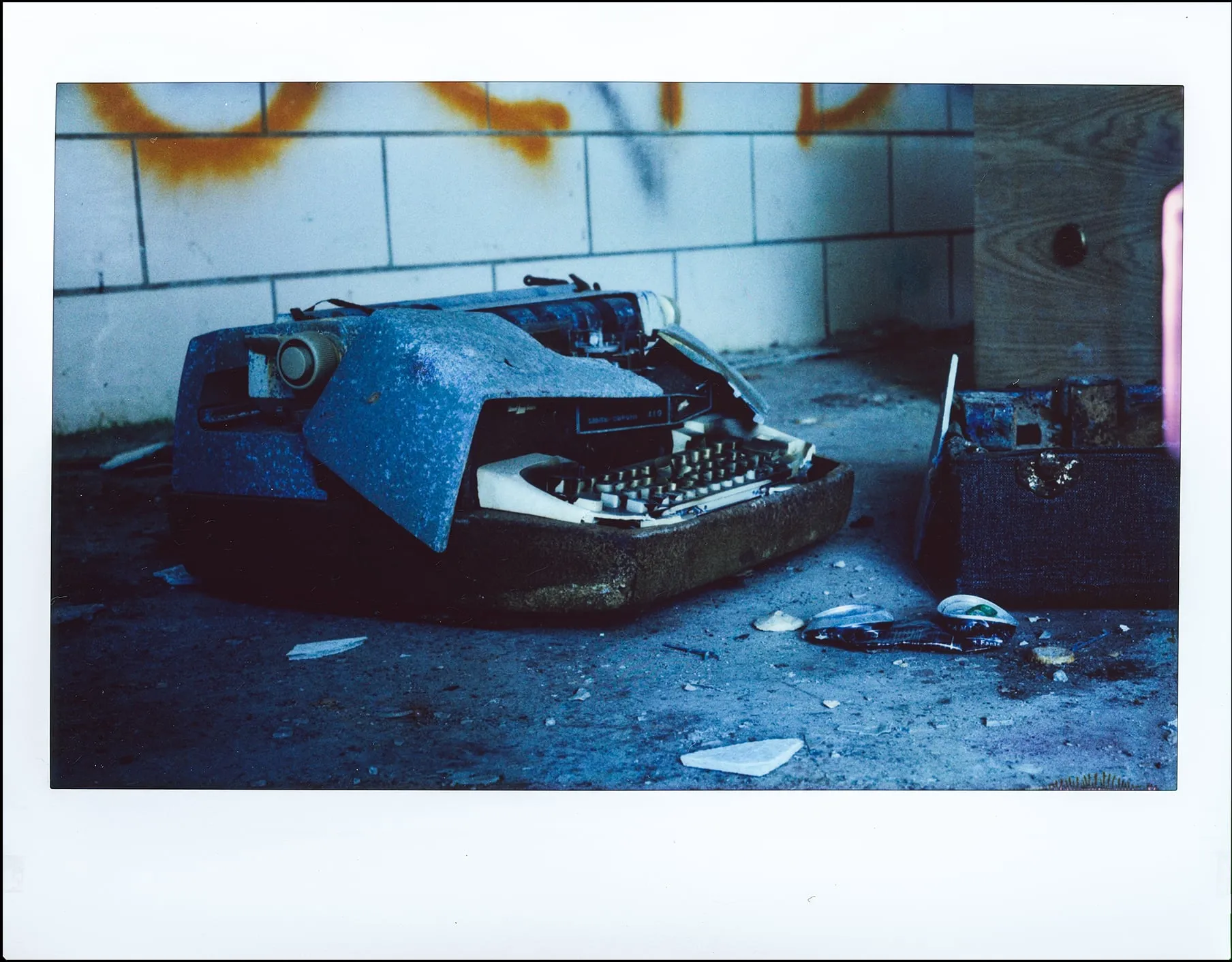 Polaroid of a smashed typewriter in an abandoned building