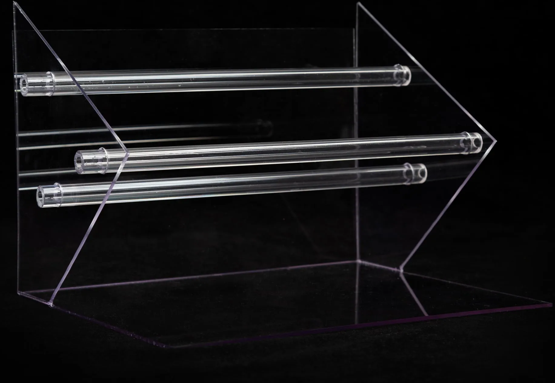 Clear acrylic rack with three rods photographed on black