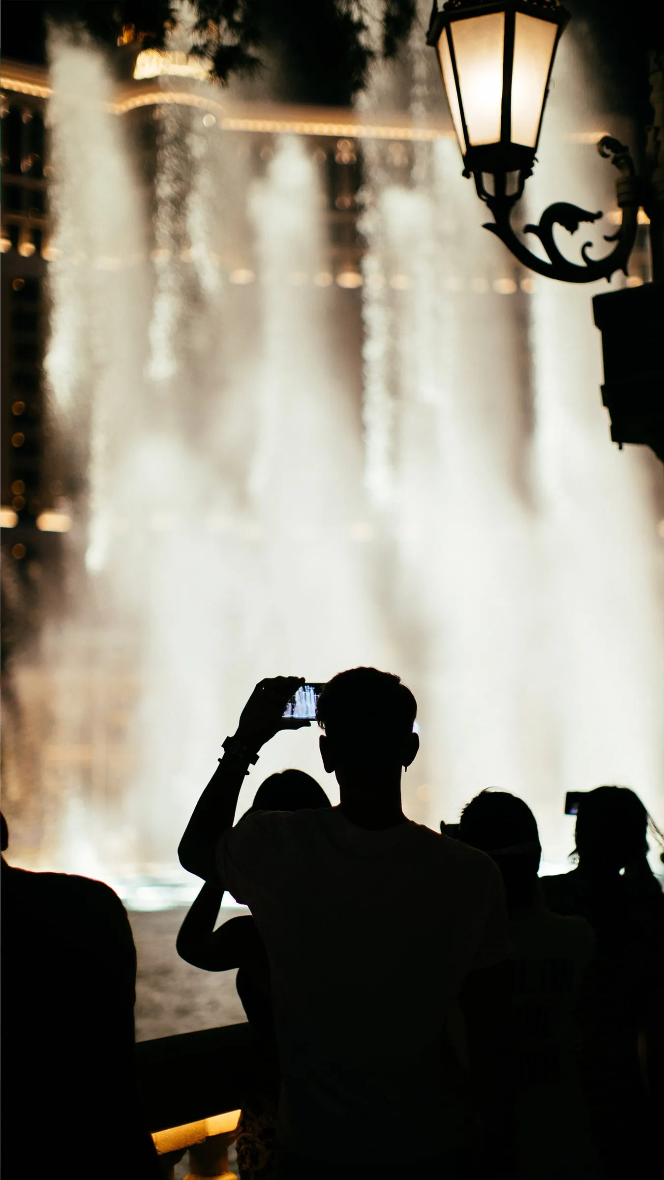 Silhouettes photographing the Bellagio fountains at dusk